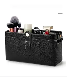 Detailed interior of a black pebble leather toiletry bag with tools and cosmetics