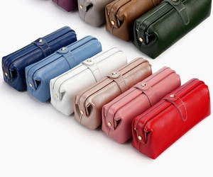 Detailed view of colorful leather makeup bags with pebble texture and snap closure