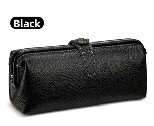 Detail of black pebbled leather cosmetic bag with white contrast stitching and gold metal hardware