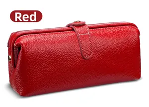 Detailed view of red lychee grain leather makeup bag with metal buckle and white stitching