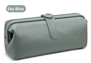 Close-up of sky blue leather makeup bag with lychee texture and gold metal clasp
