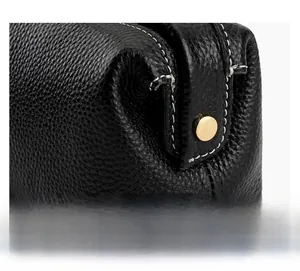 Detail of premium black pebble leather vanity bag with gold-tone hardware and fine stitching