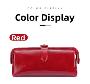 Dettaglio del beauty case in pelle cerata rossa con cuciture bianche e bottone