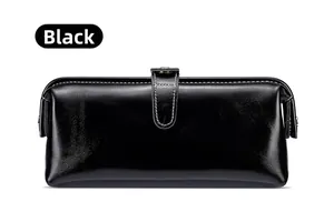 Dettaglio del beauty case in pelle nera con cuciture bianche a contrasto e bottone in metallo