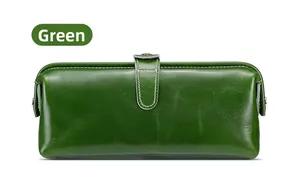 Dettaglio del beauty case in pelle verde con cuciture bianche e chiusura a scatto