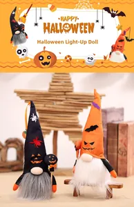 Close-up of lighted Halloween gnomes with bat and pumpkin hats on a warm wooden setting