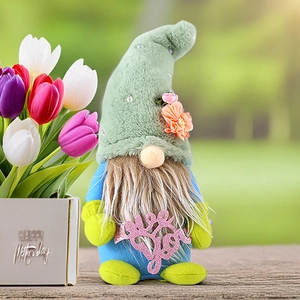 Detail of Mother's Day gnome doll holding a pink Love You sign in a garden setting
