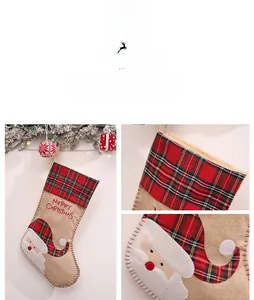 Detail von Weihnachtsstrumpf aus Jute mit Weihnachtsmann-Stickerei und rot-grünem Karomuster