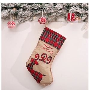 Weihnachtsstrumpf aus Leinen mit kariertem Rentier und Merry Christmas Text an der Wand