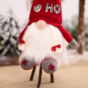 Illuminated Nordic Christmas gnome plush doll with red HO hat and white beard on snow