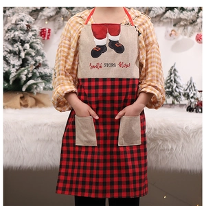 Detail of Christmas apron with Santa's boots print and dual pockets on checkered fabric