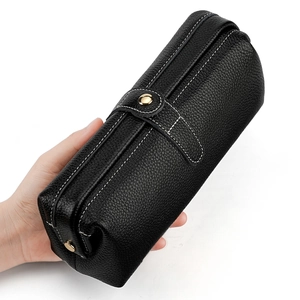 Handheld black lychee leather cosmetic bag with white contrast stitching and gold clasp