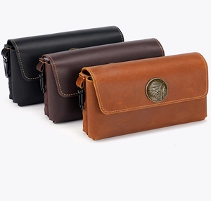 Detailed view of three vintage crazy horse leather belt pouches with tribal metal emblems