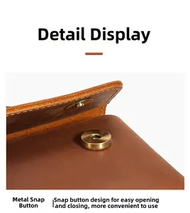 Detailed macro view of vintage leather phone pouch featuring durable brass snap button closure