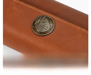 Macro detail of crazy horse leather with vintage bronze feather relief buckle