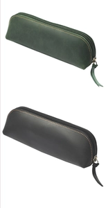 Detail of vintage leather pencil cases with rustic stitching and metal zippers