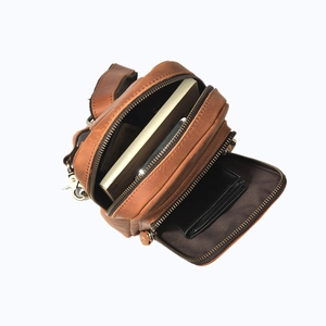 Macro view of vintage brown leather chest bag showing internal compartments and storage