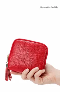 Detail of red lychee grain leather pouch with gold zipper and stylish fringe tassel