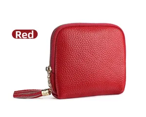 Detail of red pebbled leather jewelry pouch with gold zipper and leather tassel decoration