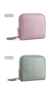 Close-up of litchi grain leather jewelry pouch with gold zippers and tassel detail