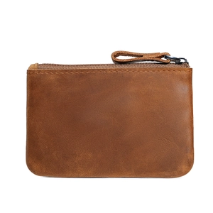 Brown crazy horse leather coin purse with zipper closure and natural texture on white background
