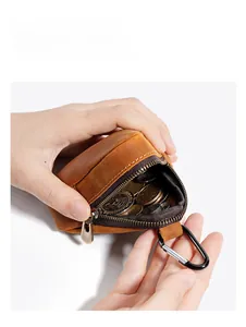 Handheld view of brown crazy horse leather coin pouch showing internal capacity for coins