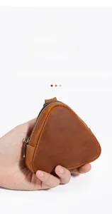 Macro detail of triangle leather coin purse showing premium brown cowhide and bronze zipper