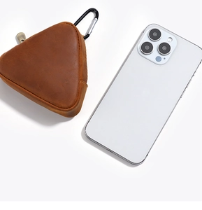 Vintage brown crazy horse leather coin pouch with carabiner shown next to a smartphone