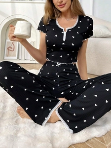 Women's black pajama set with white heart print, short sleeves and lace trim detail