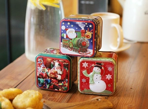 Detailed macro view of three Christmas tin boxes with festive Santa and snowman illustrations