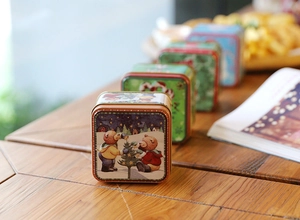 Close-up of festive Christmas square tin boxes with vintage illustration patterns