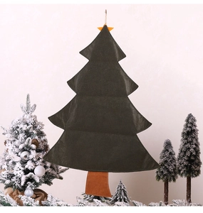 Close-up of a felt Christmas tree advent calendar hanging against a clean wall