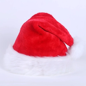 Gros plan sur la peluche rouge douce et le pompon en fourrure blanche du bonnet de Noël