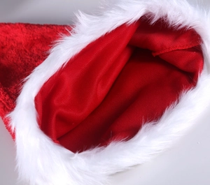 Détail du bonnet de Noël rouge en peluche montrant la doublure et le bord en fourrure blanche