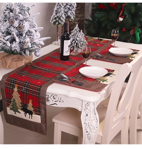 Detail of red and green plaid Christmas table runner with festive tree and deer embroidery