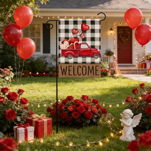 Outdoor garden flag with vintage red truck and hearts displayed in a decorated yard