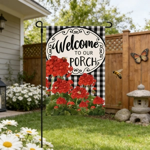 Checkered garden flag with red geraniums and Welcome to our Porch text in yard