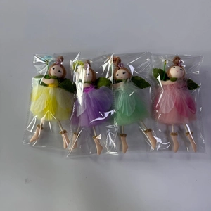 Detail of four handmade fairy pendants with colorful tulle skirts and floral headpieces