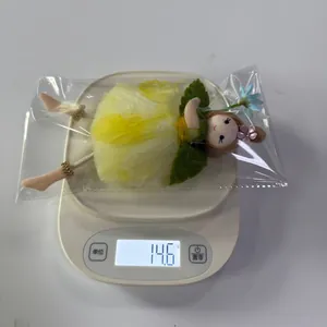 Detail view of fairy doll ornament weighing 14.6g with yellow mesh dress and green leaves