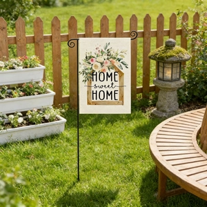 Detailed garden flag with Home Sweet Home text and floral design on a sunny green lawn