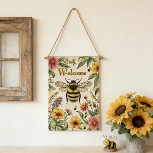 Detailed close-up of a rustic linen garden flag with welcome text and honey bee pattern