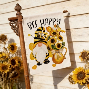 Detail of Bee Happy garden flag with gnome and sunflower hanging on a wooden wall