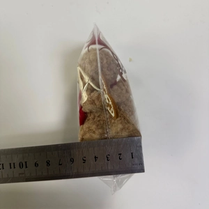 Dettaglio della misurazione della larghezza di 6,5 cm del peluche orsetto marrone