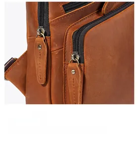 Close-up of dual zipper closure on a brown crazy horse leather sling chest bag