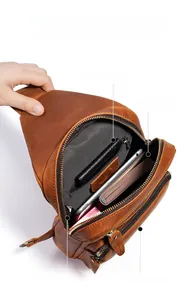 Detailed view of genuine leather chest bag showing multiple internal compartments and zippers