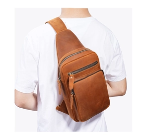Rear view of man wearing brown leather crossbody sling bag with multiple zip pockets