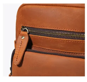 Detailed close-up of premium brown leather texture with golden metal zipper and stitching