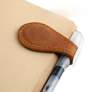 Macro di un segnalibro magnetico in pelle retrò con passante per penna e cuciture a mano