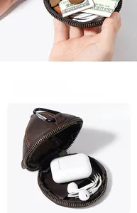 Dettaglio macro del portamonete in pelle marrone con cerniera e moschettone per accessori