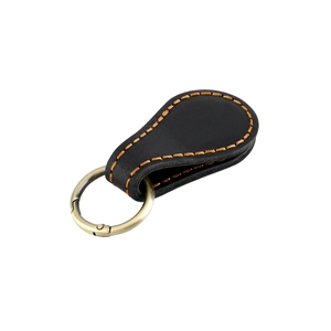 Détail d'un porte-clés en cuir avec couture orange et anneau en bronze vintage